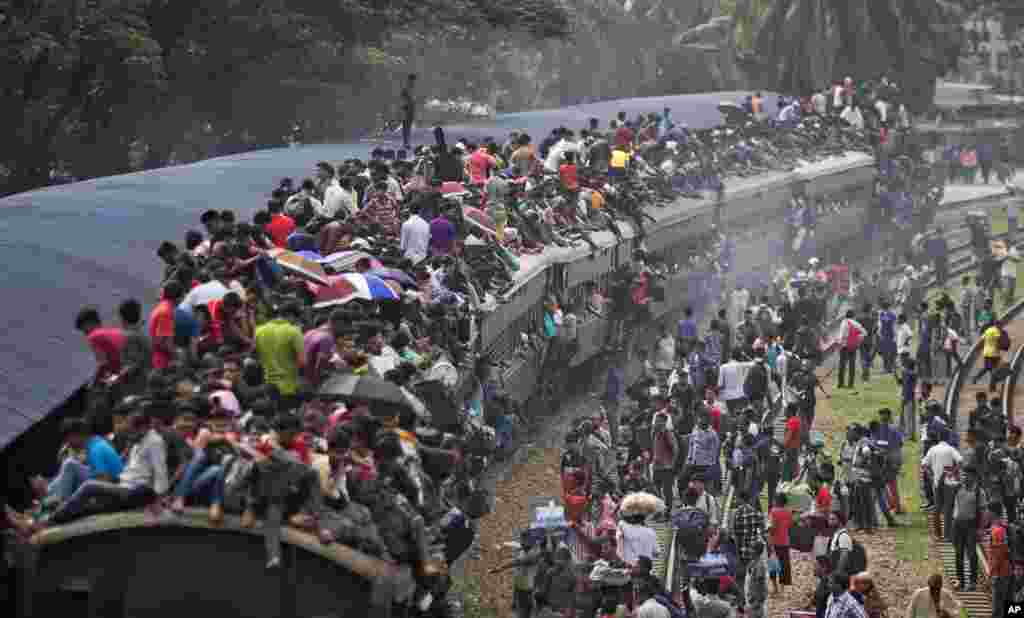 Muslims get on the roof of an overcrowded train to travel home for Eid al-Fitr celebrations, at a railway station in Dhaka, Bangladesh.