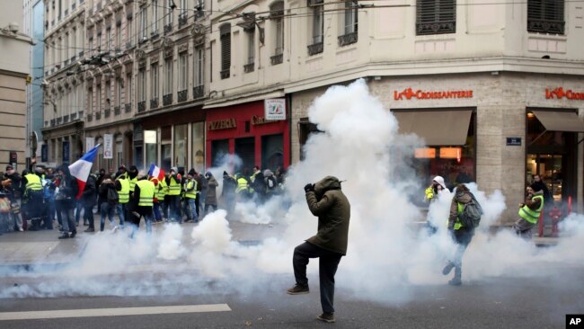 示威者于2018年12月15日在法国中部的里昂逃离催泪瓦斯。