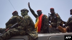 Le lieutenant-colonel Mamady Doumbouya (au centre), chef des putschistes, salue la foule à son arrivée au Palais du peuple à Conakry, le 6 septembre 2021.