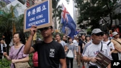 Protesters hold placards and wave Hong Kong colonial flags during the annual pro-democracy protest in Hong Kong. As the Asian financial center prepares for legislative elections in September, a new wave of radical political activists are planning to join the campaign, including some who advocate the once-unthinkable idea of independence from China, July 1, 2016.