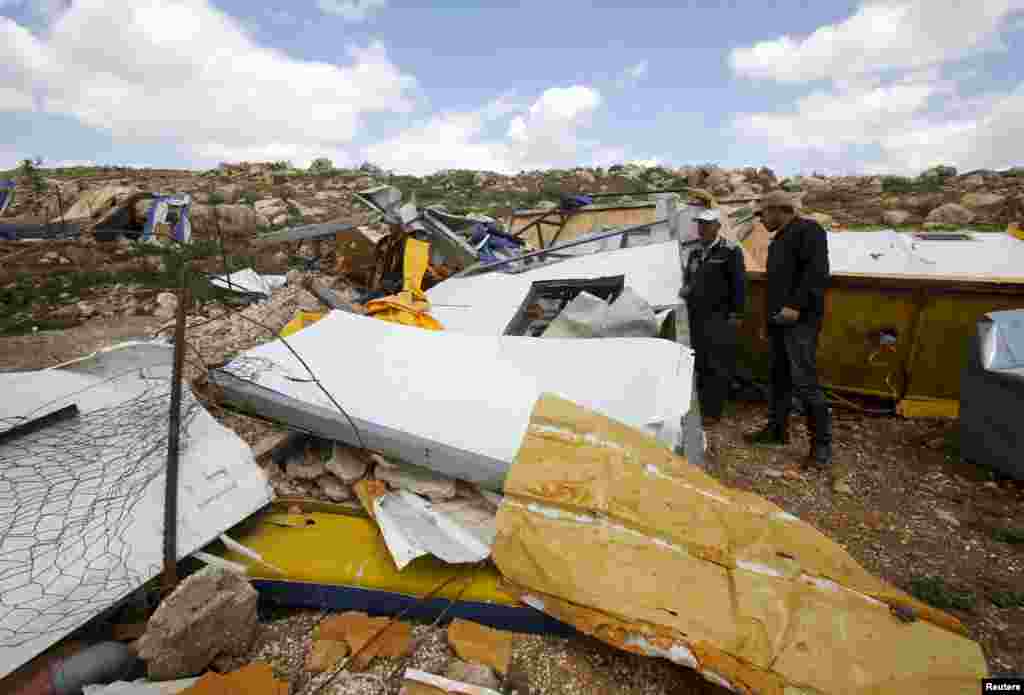 Palestinians look at the remains of a school project that was funded by the European Commission Humanitarian Aid and Civil Protection (ECHO) and was demolished by Israeli forces, in Khirbet Tana near the West Bank city of Nablus.