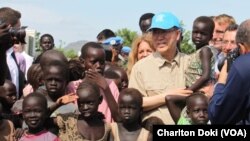 UN Secretary General Ban Ki-moon holds a child as he visits a UN compound in Juba on May 6, 2014, where thousands of people displaced by five months of fighting have sought shelter. The hair of many of the children is beginning to turn red, a sign of maln