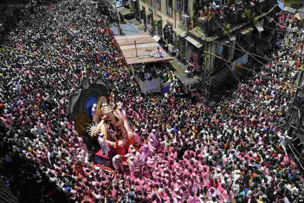 Hindu devotees participate in a procession towards the Arabian Sea with a giant idol of the elephant-headed god Ganesha to immerse it on the final day of the ten-day long Ganesha Chaturthi festival in Mumbai, India.