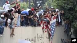Protesters destroy an American flag pulled down from the U.S. Embassy in Cairo, Egypt, Sept. 11, 2012