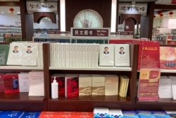 FILE - Uyghur-language copies of writings by Mao Zedong and Chinese President Xi Jinping sit on the shelves of the "ethnic minority language book" section of a bookstore in Aksu, in China's far west Xinjiang region, March 18, 2021.