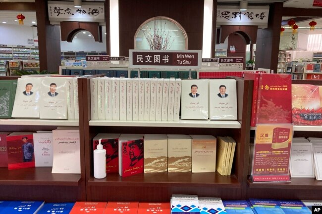 FILE - Uyghur-language copies of writings by Mao Zedong and Chinese President Xi Jinping sit on the shelves of the