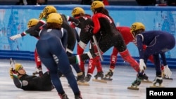 Italy's Arianna Fontana (L) falls in the women's short track speed skating relay final event at the 2014 Sochi Winter Olympics Feb. 18, 2014.