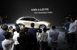 Hyundai Motor Co.'s new hydrogen fuel cell vehicle is surrounded by members of media during a media preview in Seoul, South Korea, Thursday, Aug. 17, 2017. (AP Photo/Lee Jin-man)