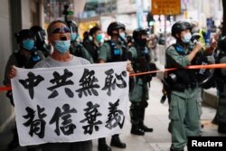 一名香港抗议者在主权回归纪念日举行的抗议港版国安法游行中举牌指责中共背信弃义。（2020年7月1日）