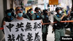 一名香港抗議者在主權回歸紀念日舉行的抗議港版國安法遊行中舉牌指責中共背信棄義。（2020年7月1日）