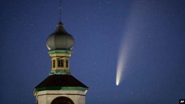 The comet Neowise or C/2020 F3 is seen behind an Orthodox church over the Turets, Belarus, 110 kilometers (69 miles) west of capital Minsk, early Tuesday, July 14, 2020. (AP Photo/Sergei Grits)