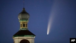 The comet Neowise or C/2020 F3 is seen behind an Orthodox church over the Turets, Belarus, 110 kilometers (69 miles) west of capital Minsk, early Tuesday, July 14, 2020. (AP Photo/Sergei Grits)
