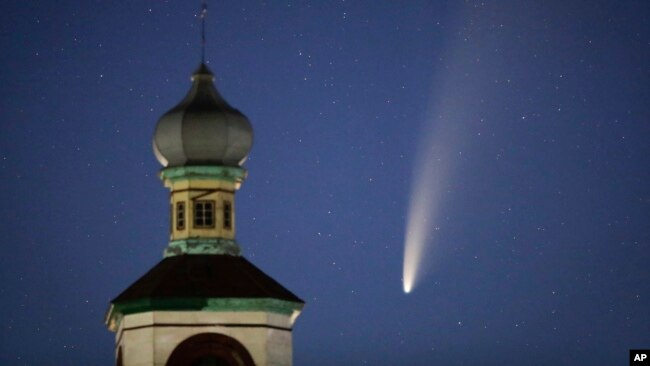 The comet Neowise or C/2020 F3 is seen behind an Orthodox church over the Turets, Belarus, 110 kilometers (69 miles) west of capital Minsk, early Tuesday, July 14, 2020. (AP Photo/Sergei Grits)