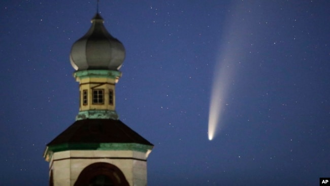 The comet Neowise or C/2020 F3 is seen behind an Orthodox church over the Turets, Belarus, 110 kilometers (69 miles) west of capital Minsk, early Tuesday, July 14, 2020. (AP Photo/Sergei Grits)