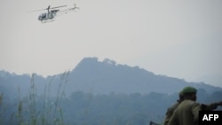 Un hélicoptère des Nations Unies survole des soldats des Forces armées de la République démocratique du Congo (FARDC) dans le parc national des Virunga, à environ 20 km de la ville de Goma, RDC, 11 juillet 2012.