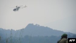 Un hélicoptère des Nations Unies survole des soldats des Forces armées de la République démocratique du Congo (FARDC) dans le parc national des Virunga, à environ 20 km de la ville de Goma, RDC, 11 juillet 2012.