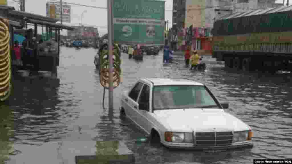 Un homme prend le risque de conduire sans voir les bords de la route inondée dans un quartier avoisinant le stade de l&#39;amitié aujourd&#39;hui baptisé stade Général Mathieu Kerekou, à Cotonou, Bénin, 8 octobre 2016. VOA/Ginette Fleure Adande