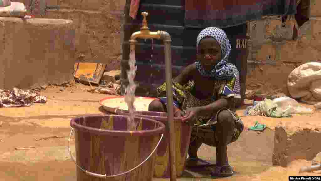 Une petite fille tire de l'eau dans le centre de transition des repentis de Diffa, Niger, le 17 avril 2017 (VOA/Nicolas Pinault)