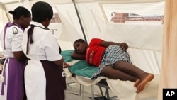 A woman is attended to after suffering from a suspected case of typhoid at a local hospital in Harare, January 31, 2012.
