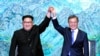 North Korean leader Kim Jong Un, left, and South Korean President Moon Jae-in raise their hands after signing a joint statement at the border village of Panmunjom in the Demilitarized Zone, South Korea, April 27, 2018.