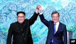FILE - North Korean leader Kim Jong Un, left, and South Korean President Moon Jae-in raise their hands after signing a joint statement at the border village of Panmunjom in the Demilitarized Zone, South Korea, April 27, 2018.