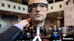 An engineer makes an adjustment to the robot "The Incredible Bionic Man" at the Smithsonian National Air and Space Museum in Washington, Oct. 17, 2013.