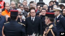 Presiden Perancis Francois Hollande, kiri, dan Perdana Menteri Manuel Valls, kanan, meletakkan karangan bunga saat upacara peringatan korban serangan di Place de la Republique, Paris, 10 Januari 2016.