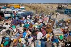 FILE - Civilians who fled recent fighting stack their belongings up outside the gate of the United Nations Mission compound in South Sudan (UNMISS), hoping to benefit from their protection, Unity State, South Sudan, Jan 12, 2014.