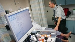 Dr. Jacob Khushigian checks on a patient who had overdosed - also showing his computer data base that lets doctors know what drugs their patients already are taking - shown in a Kaweah Delta Emergency Room in Visalia, California, February 2010.