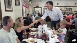 Former Massachusetts Gov. Mitt Romney shakes hands with people at Farm Boys restaurant during a visit in Chapin, S.C. Republican presidential frontrunner Romney is heading to Iowa on Friday for the first time this year, May 21, 2011