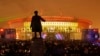 People watch a light show at the new soccer stadium on Krestovsky Island, which will host some 2018 World Cup and 2017 Confederations Cup matches, in St. Petersburg, Russia, April 22, 2017. A statue of Sergei Kirov, an early Bolshevik leader, is in the fo