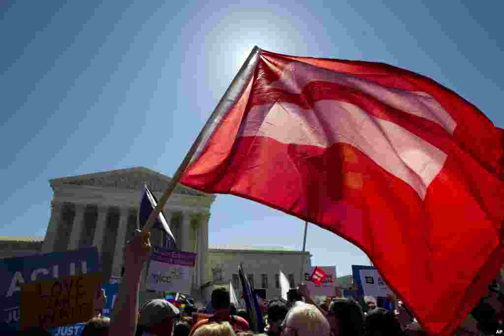 Một lá cờ biểu tượng cho bình đẳng hôn nhân trong một cuộc biểu tình trước Tòa án Tối cao ở Washington, Mỹ. Tòa án Tối cao sẽ nghe những lập luận mang tính lịch sử trong những vụ khiếu kiện mà có thể biến hôn nhân đồng tính trở thành luật toàn quốc.