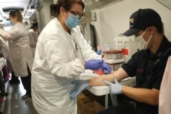 El bombero de Jersey City, Nueva Jersey, Matt Finnerty, se extrajo sangre para detectar anticuerpos contra el coronavirus en un sitio de prueba en Jersey City, el 4 de mayo de 2020.