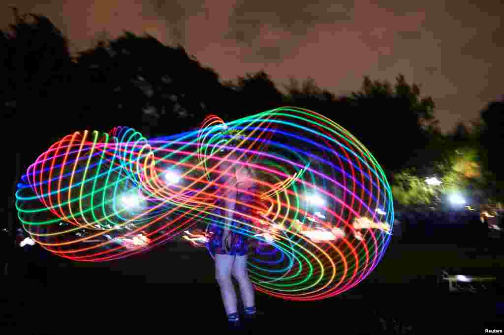 A woman dances with light at an event called &#39;Catharsis on the Mall&#39; in Washington, May 4, 2019.