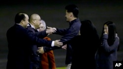 Kenneth Bae, second from left, who had been held in North Korea since 2012, is greeted after arriving at Joint Base Lewis-McChord, Washington, Nov. 8, 2014.