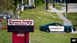 Polisi memblokade gerbang masuk menuju Sekolah Marjory Stoneman Douglas di Parkland, Florida, pada 15 Februari 2018, menyusul tragedi penembakan yang terjadi di lokasi tersebut. (Foto: AP/Wilfredo Lee)