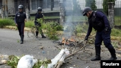 Police officers remove debris used by demonstrators to block a street during a protest against the gas shortage in San Cristobal, Venezuela, Sept. 21, 2018.