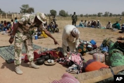 FILE - Soldiers screen newly arrived displaced people at Furore camp in Yola, Nigeria on Dec. 8, 2015, who claim they were chased out of their villages by Cameroon troops.