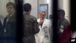 FILE - South Korean army soldiers talks with a medical doctor as he prepares to treat an unidentified injured person, unseen, believed to be a North Korean soldier, at a hospital in Suwon, South Korea, Nov. 13, 2017.