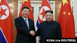 Pemimpin Korea Utara Kim Jong Un berjabat tangan dengan Presiden China Xi Jinping selama kunjungan Xi di Pyongyang, Korea Utara dalam foto tak bertanggal yang dirilis pada 21 Juni 2019. (Foto: KCNA via REUTERS)