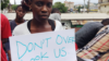 Gloria Maya Terrick holds a sign requesting the government to allow the students to help in the fight against Ebola, outside NGO headquarters, in Monrovia, Liberia, Sept. 29, 2014. (Benno Muchler/VOA)