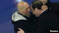 Serge Lazarevic abraça François Hollande à chegada a França