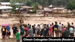 People help to rescue flood victims in Lanao Del Norte, Philippines, Dec. 22, 2017, in this image taken from video footage obtained from social media. Climah Cabugatan Disumala/via Reuters