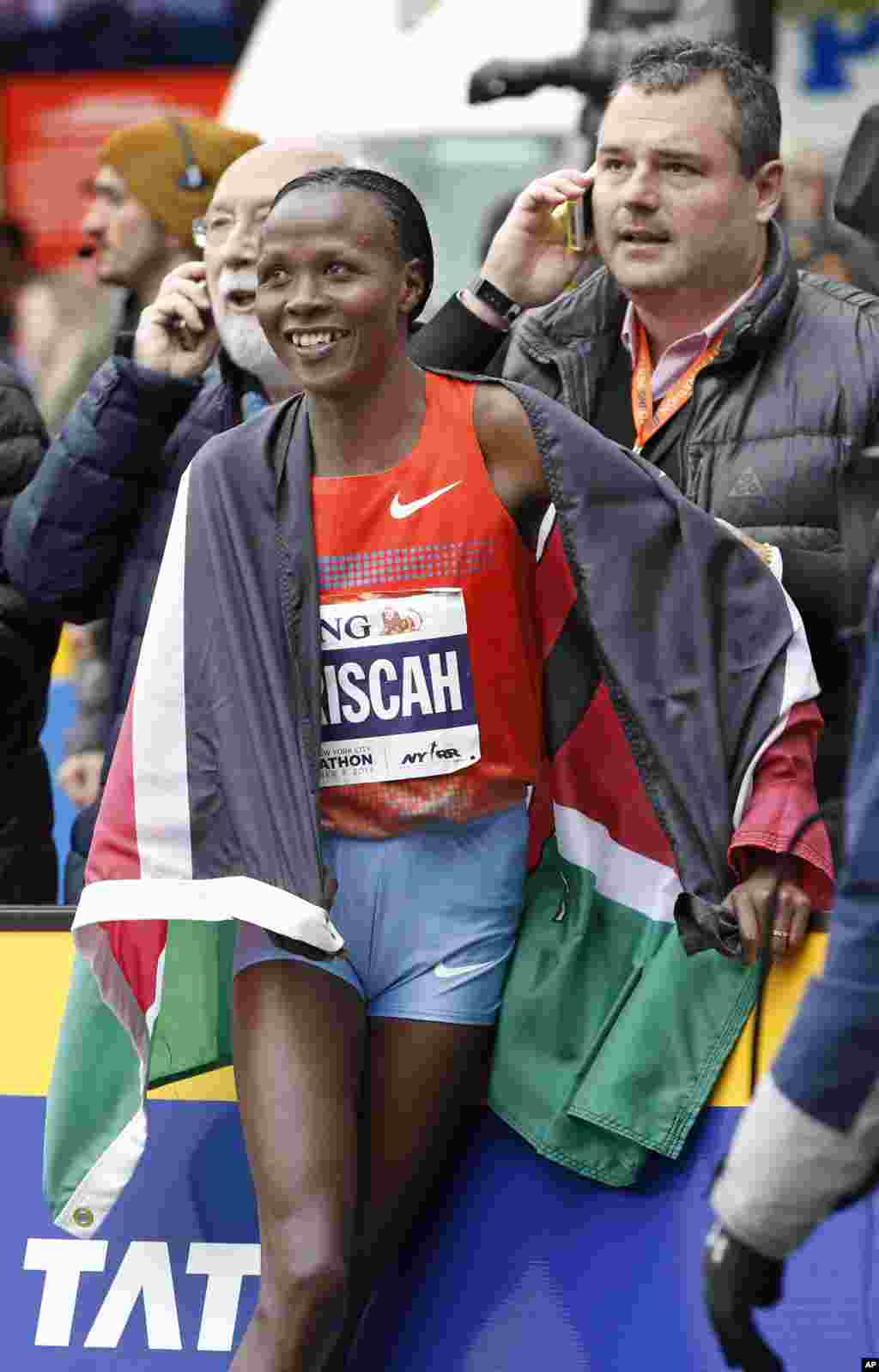 Women's winner Priscah Jeptoo of Kenya reacts with members of her team after coming in first in the women's division of the New York City Marathon, Nov. 3, 2013, in New York. 