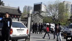 Police officers watch over an area where members of an underground church had planned to gather for worship in Beijing, China, April 17, 2011