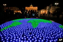 A globe illuminated with led-lights by activists of the World Wide Fund For Nature sits in front of the Brandenburg Gate to mark Earth Hour, in Berlin, March 25, 2017.