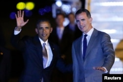 U.S. President Barack Obama, left, waves as is welcomed by Spain's King Felipe following his arrival aboard Air Force One at the Torrejon airbase, outside Madrid, Spain, July 9, 2016.
