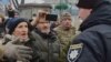 FILE - A Pro-Russian activist waves a Donbas Republic flag over a crowd celebrating the capture of an administration building in the center of Luhansk, Ukraine, one of the largest cities in Ukraine's troubled east, April 29, 2014.