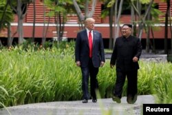 도널드 트럼프 미국 대통령과 김정은 북한 국무위원장이 지난 6월 싱가포르 카펠라 호텔에서 오찬을 마친 뒤 함께 산책하고 있다.