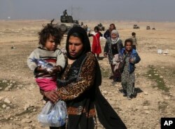 Displaced Iraqis flee their homes due to fighting between Iraqi special forces and Islamic State militants, on the western side of Mosul, Iraq, Feb. 2017.